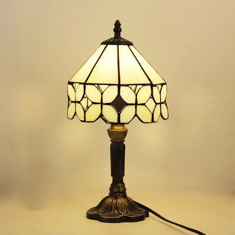 A vintage-style e27 retro baroque led table lamp with cream stained glass shade and dark bronze metalwork for decor