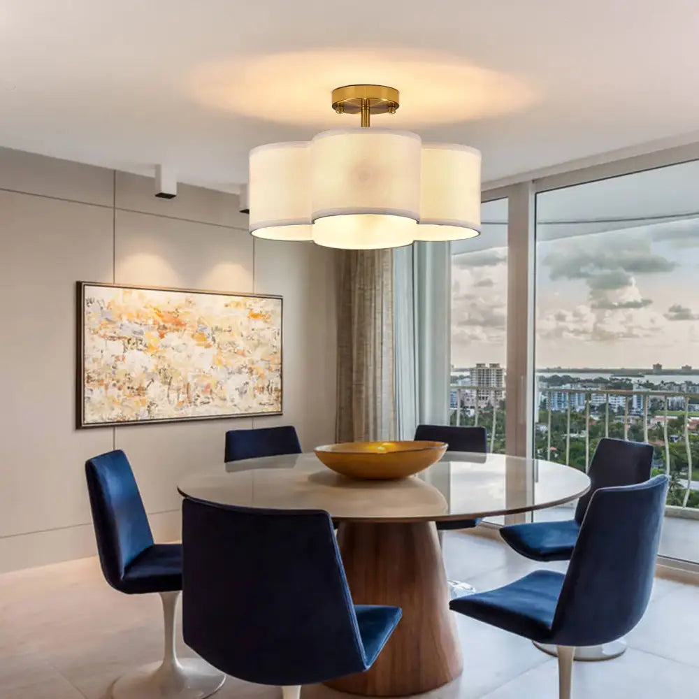 Decorbites™ elegant 4-light gold ceiling fixture with three cylindrical white fabric shades and a brass-finished light fixture