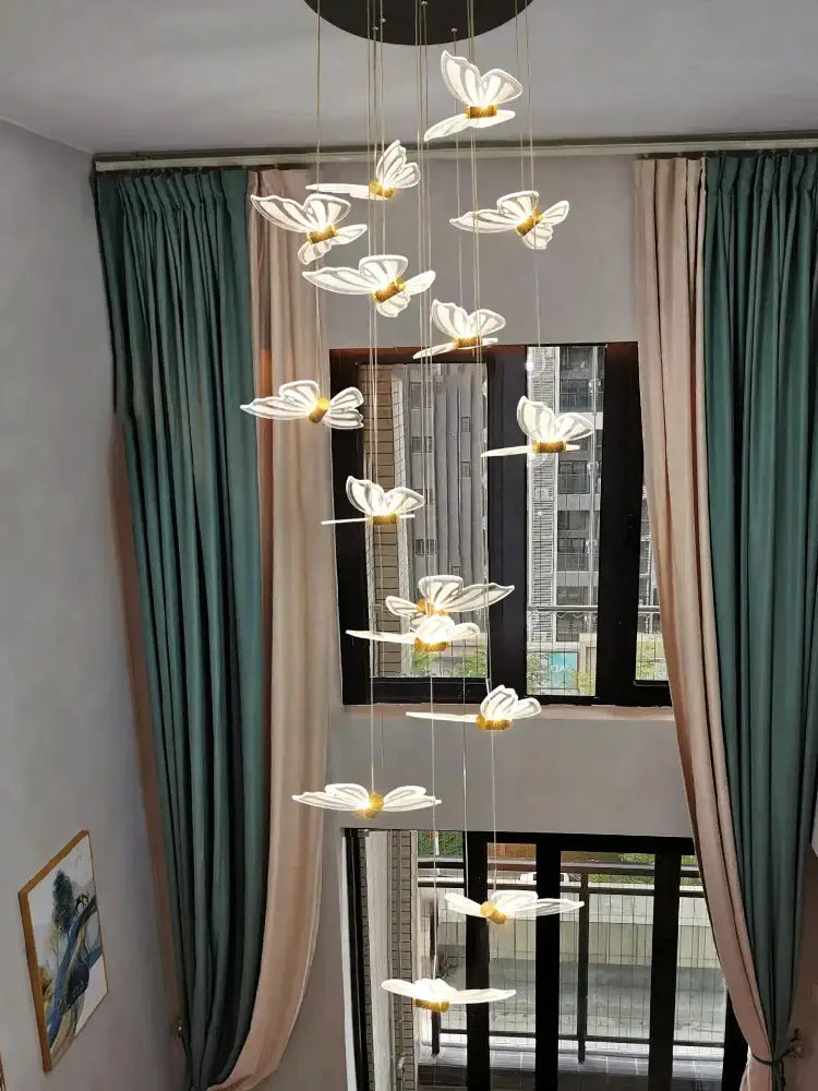 A decorbites elegant butterfly chandelier featuring white translucent butterfly lights with gold centers on a dark base