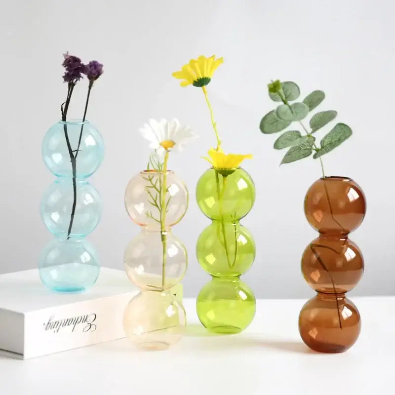 Set of four DecorBites™ elegant glass vases in pastel blue, peach, lime green, and amber brown for home decor