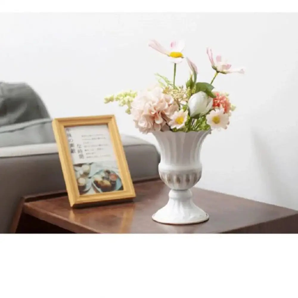 White ceramic flower vase with fluted rim and decorative band holding pink white and peach flowers from DecorBites metal flower vase collection
