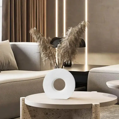 White circular ceramic donut vase with central hole holding dried pampas grass for elegant home decor by DecorBites™