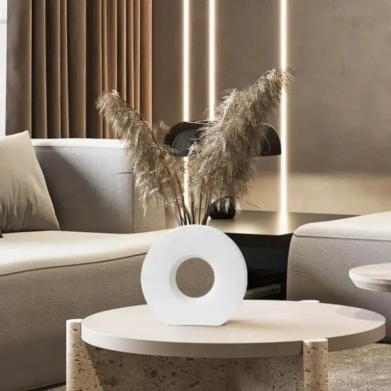 White circular ceramic donut vase with central hole holding dried pampas grass for elegant home decor by DecorBites™