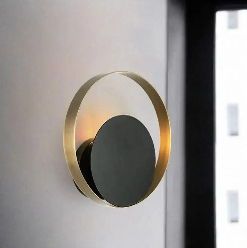 DecorBites Ellen modern wall sconces with brushed gold ring and matte black disc emitting warm ambient light