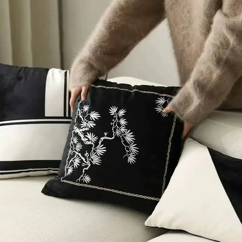 Black velvet cushion cover with intricate white embroidered pine branches and delicate chain-stitched border decorbites embroidered black white
