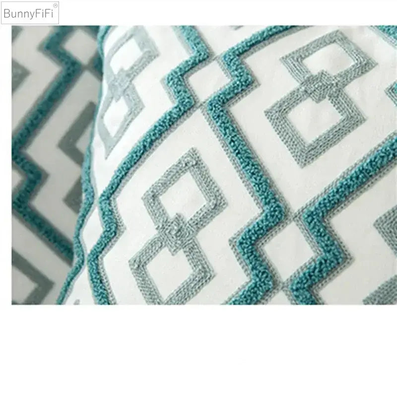A white cushion cover with teal and gray embroidered blue cotton zigzag pattern by Decorbites for living room decor
