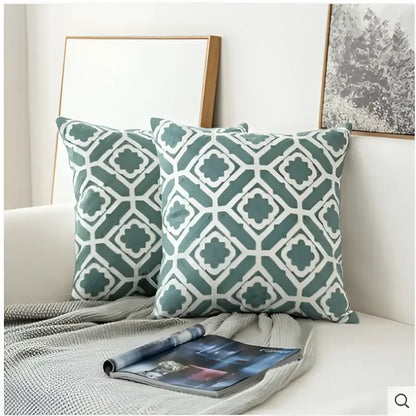 Two teal and white geometric patterned decorbites embroidered blue cotton cushion covers with soft textured fabric finish