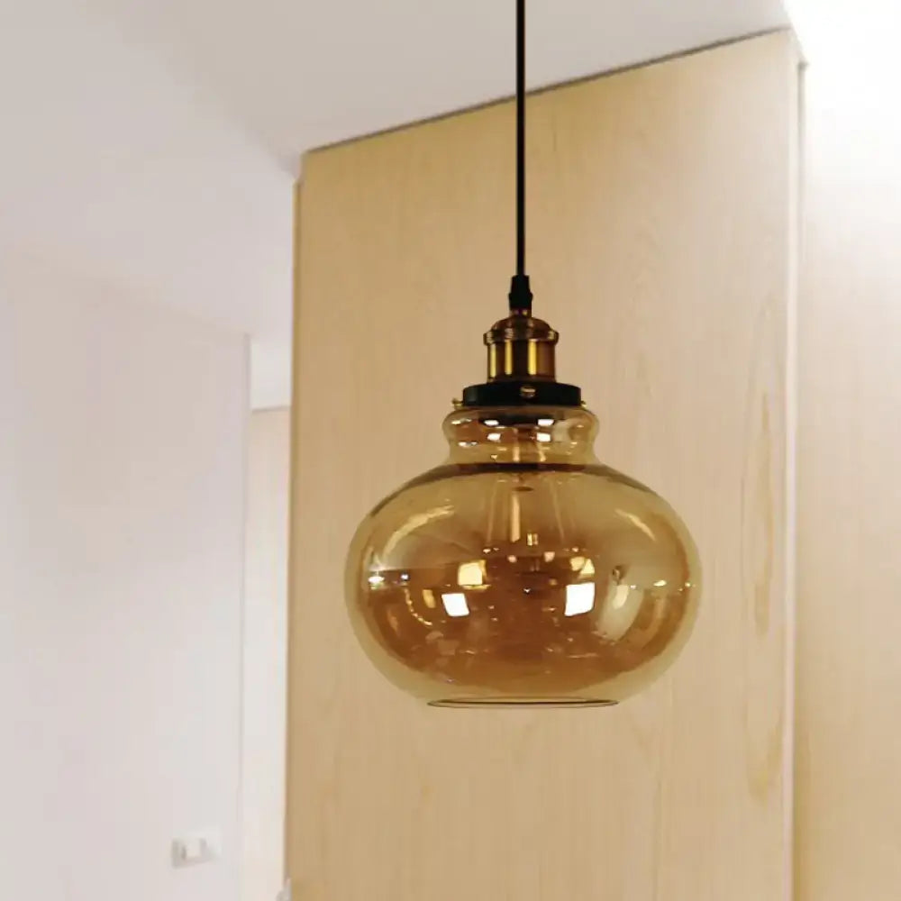Decorbites farmhouse brass pendant ceiling light featuring amber glass globe with brass fixture and black cord for indoor use