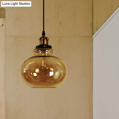 Decorbites farmhouse brass pendant ceiling light featuring an amber glass globe with brass fixture and black cord for indoor use