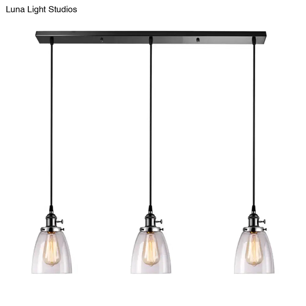 Black metal pendant light with linear canopy and three clear glass ribbed shades featuring exposed filament bulbs