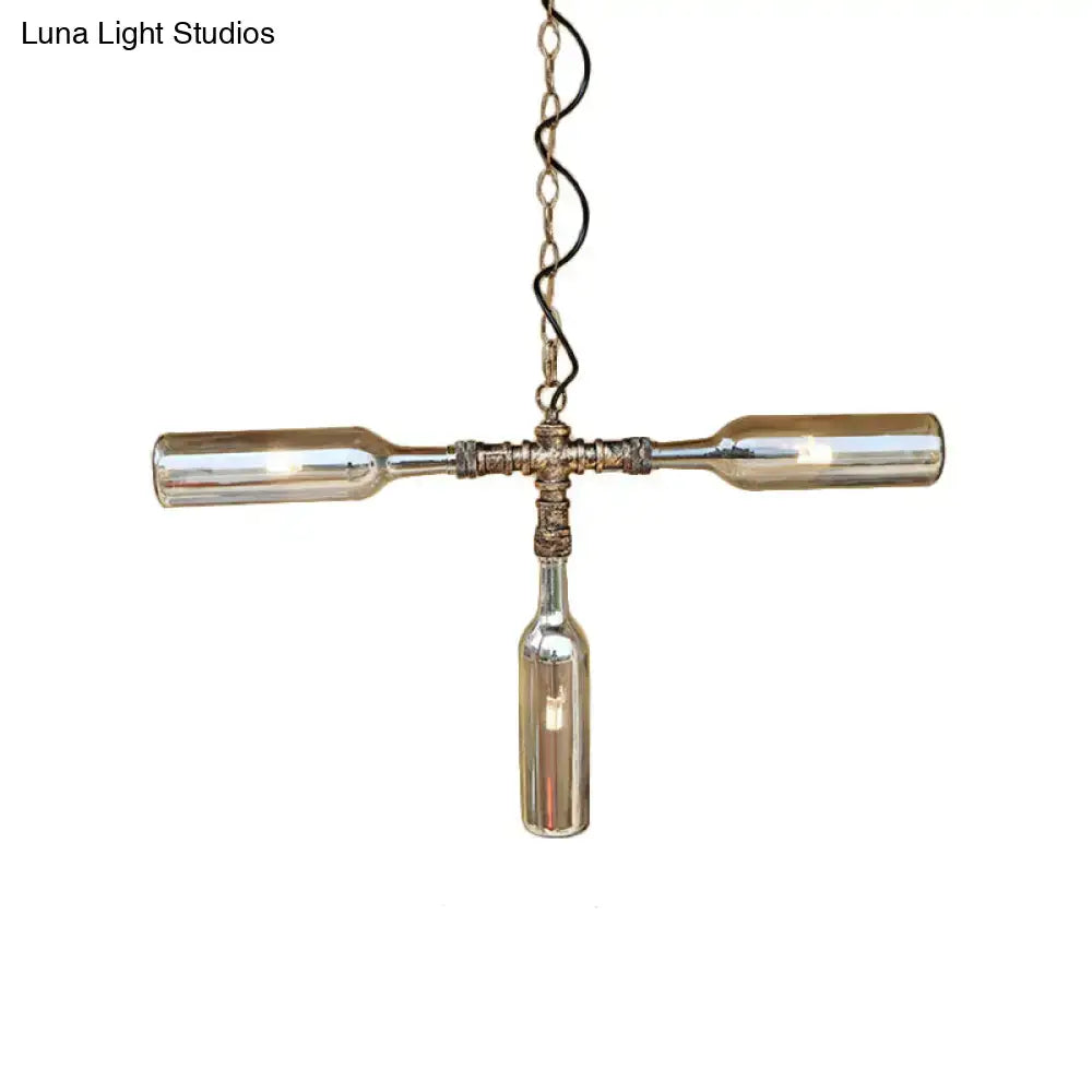 A rustic farmhouse style pendant light with three smoke gray blue glass bottles and aged silver black metal fixtures
