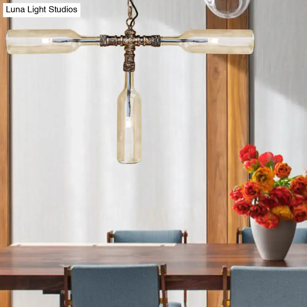 Industrial pendant light with three smoke gray blue glass bottles and aged silver black brass pipe frame illuminated warmly