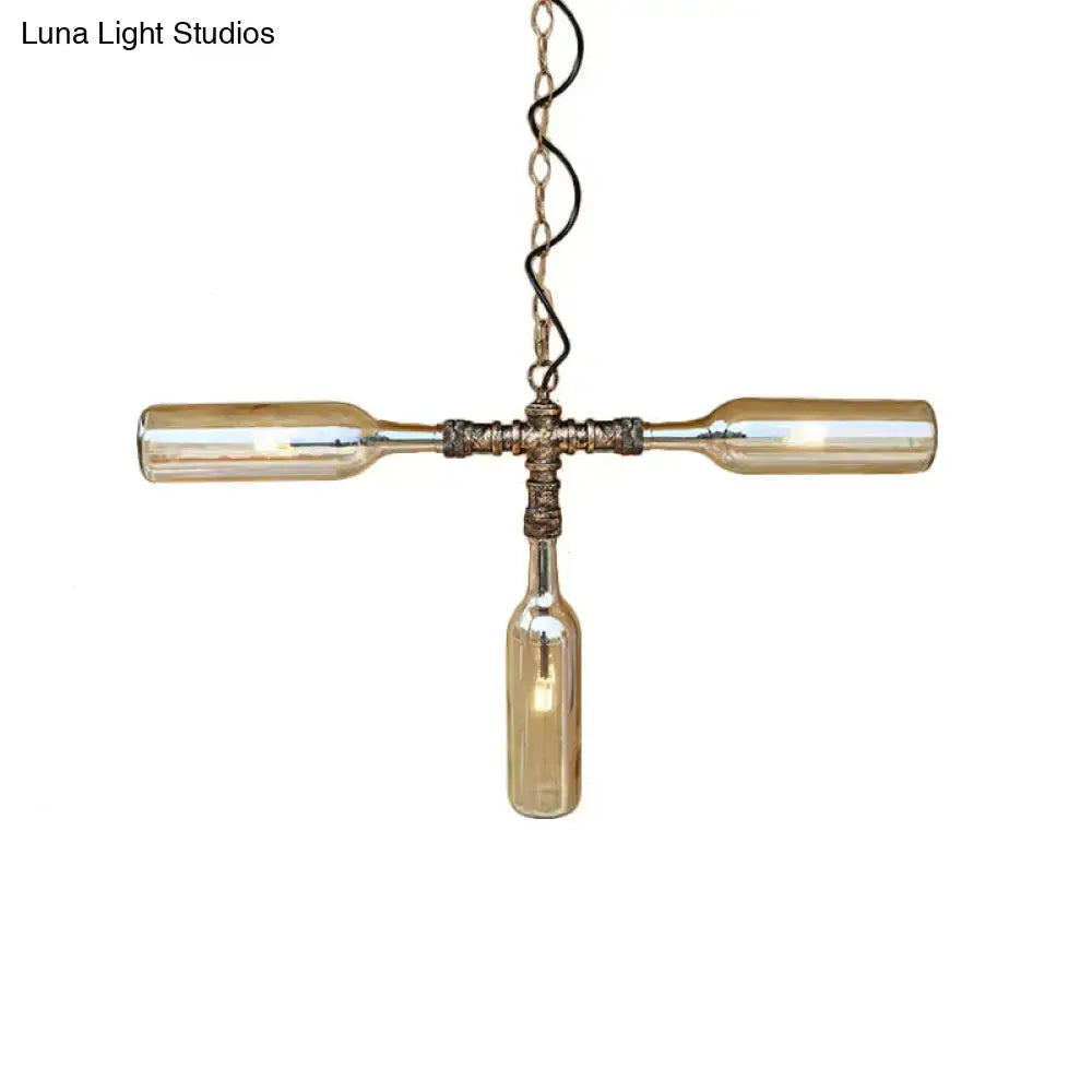 A rustic farmhouse style pendant light with three amber glass bottles in aged silver black and smoke gray blue finish