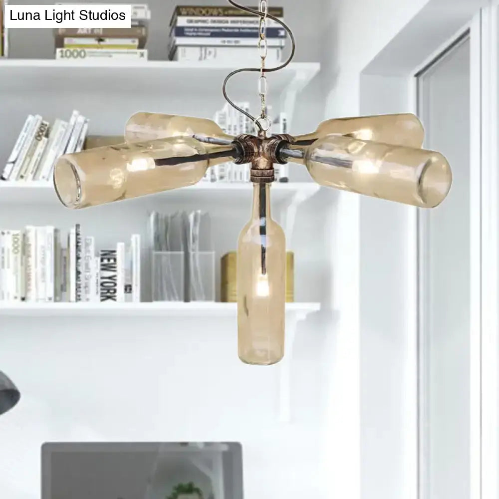 A rustic amber glass bottle chandelier with four arms in aged silver black metal for farmhouse style lighting