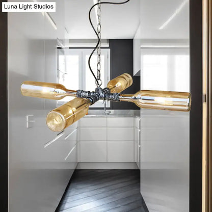 Industrial chandelier with four amber glass wine bottles in aged silver black and smoke gray blue finish by DecorBites