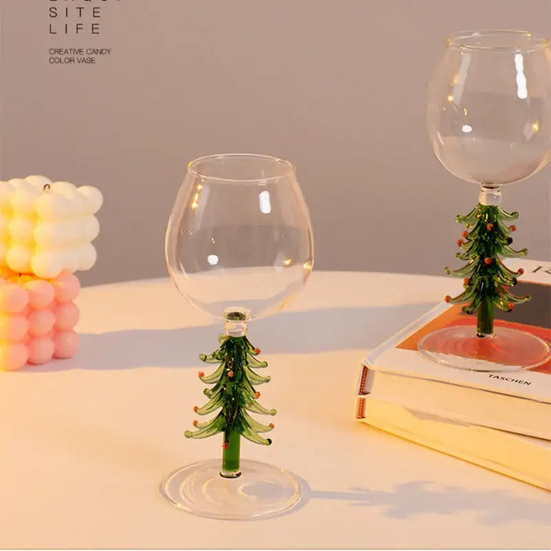 Clear glass christmas wine glasses with green tree-shaped stems and orange accents for festive christmas wine use