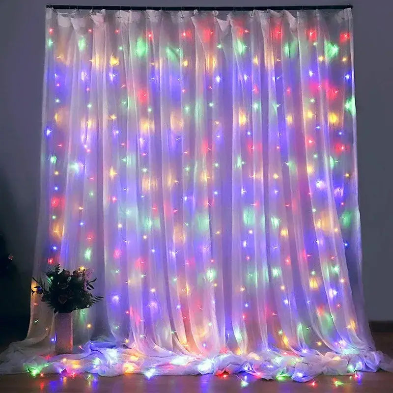 A sheer white curtain decorated with colorful red green blue and purple led fairy lights in 6x3m and 3x3m sizes by decorbites