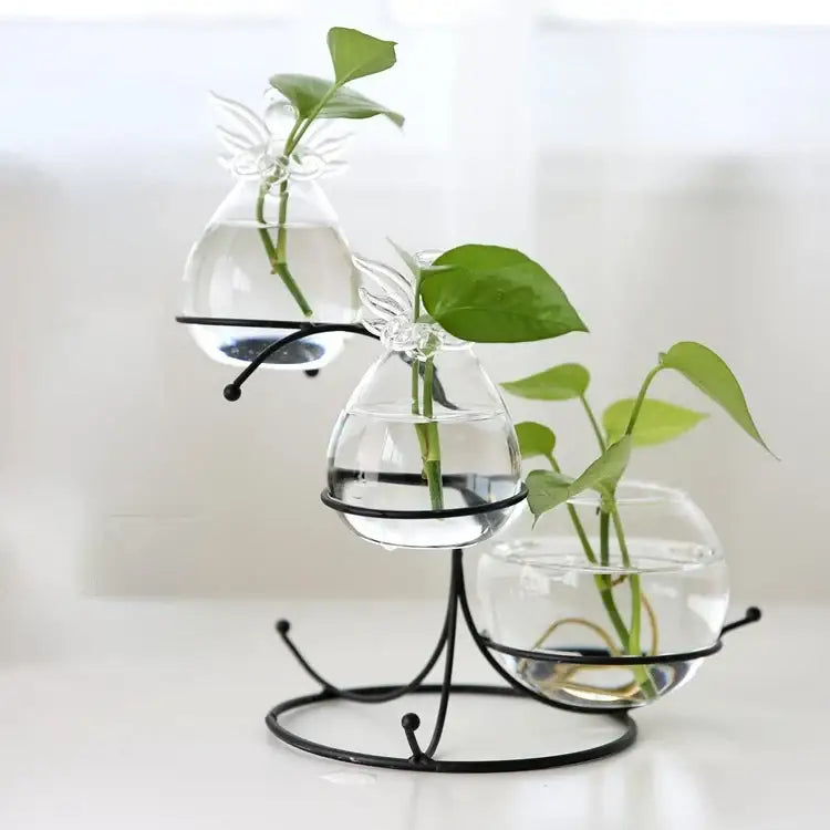 DecorBites™ flamingo metal vase featuring clear glass terrariums with angel-wing embellishments on a black metal stand