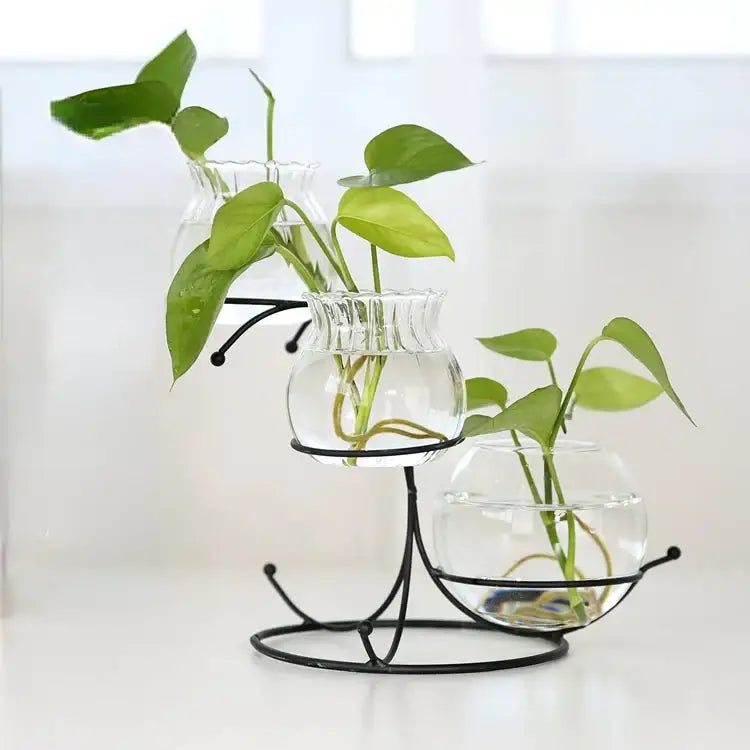 Clear glass vases with scalloped rims on a black flamingo metal vase stand for elegant home decor