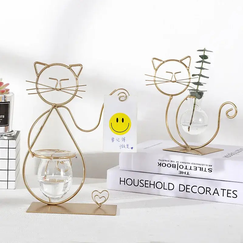 Gold wire cat-shaped candle holder with clear glass base featured as a decorative element in DecorBites™ flamingo metal vase home decor