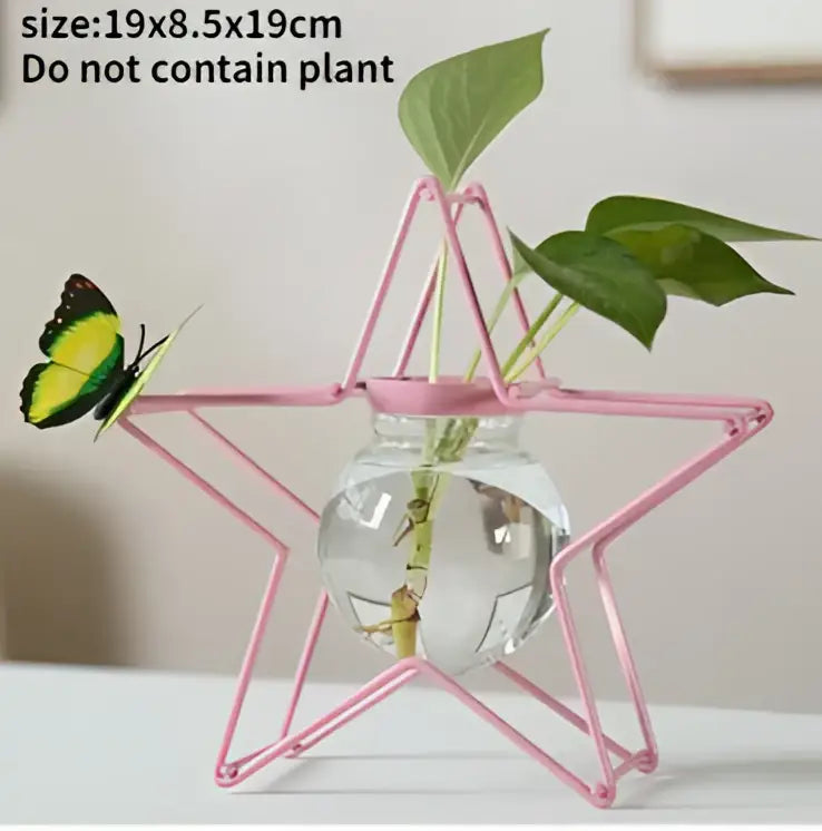 DecorBites™ flamingo metal vase is a pink star-shaped metal vase with a glass sphere for home decor with green leaves