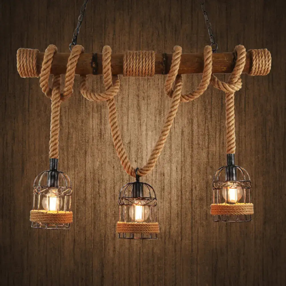 Rustic industrial ceiling light with three cast iron birdcage bulbs hanging by hemp rope from a wooden beam