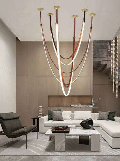 A leather belt led chandelier with curved white and brown strips suspended from gold fixtures for living room use