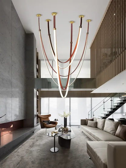 DecorBites™ LED chandelier light with flexible leather belt straps, gold fixtures, and curved illuminated tubes in modern design