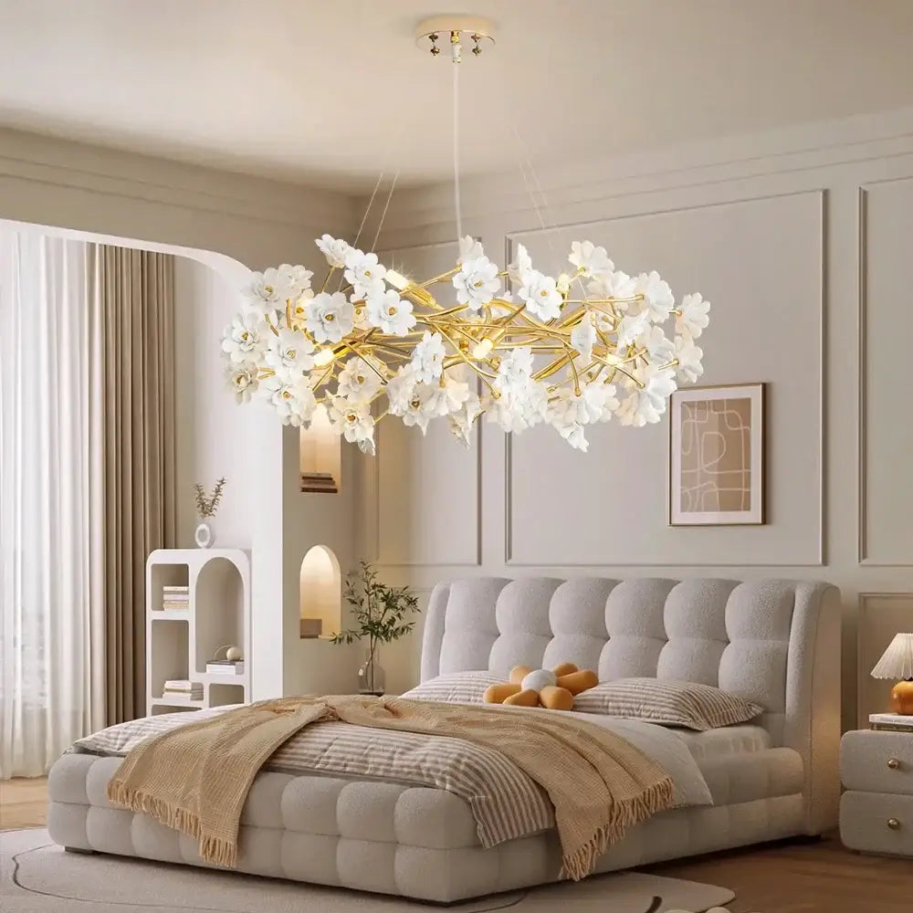 Elegant DecorBites™ floral french white ceramic chandelier with gold-toned branches hanging above tufted bed