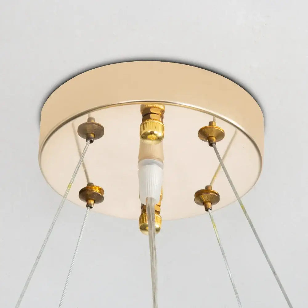 Gold-toned circular ceiling light fixture with brass hardware and clear cables for the french white flower chandelier decorbites