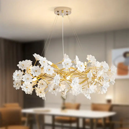 Elegant french white flower chandelier by DecorBites featuring white ceramic flowers and gold-toned metal branches with bulbs