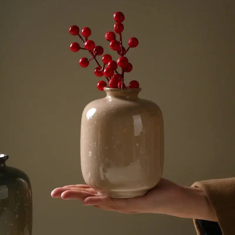 Beige glossy decor ceramic vase 13.5cm high holding vibrant red berries on slender branches