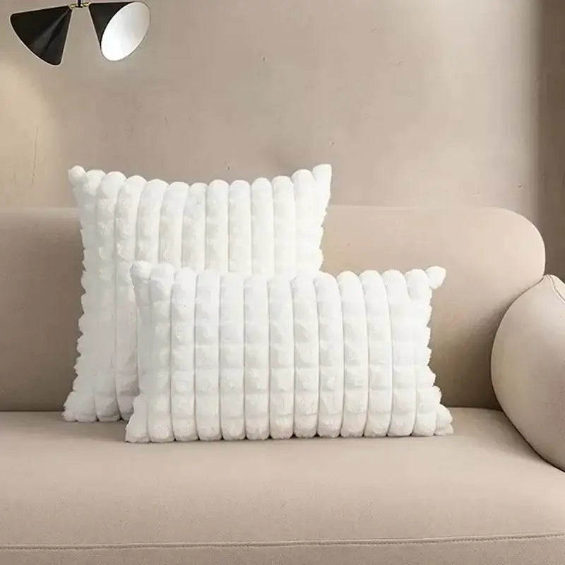 White plush throw pillows with textured ribbed design on beige sofa featuring decorbites fluffy faux fur cushion cover