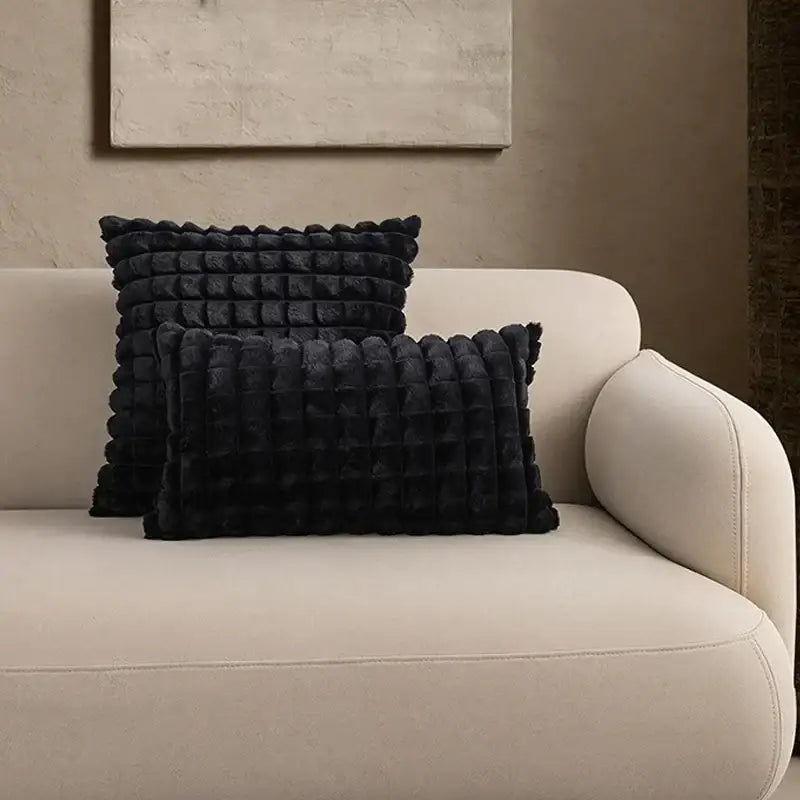 Black plush throw pillows with textured quilted design on beige sofa featuring decorbites fluffy faux cushion cover