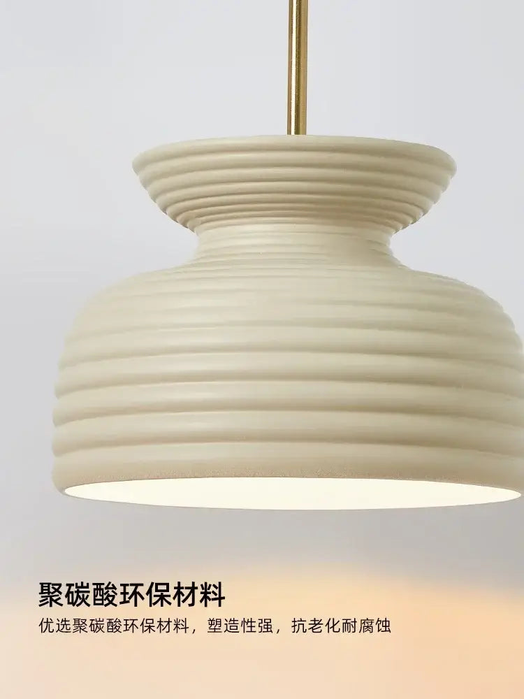 Cream-colored decorbites french minimalist pendant light with ribbed texture and gold-toned hanging rod for dining room