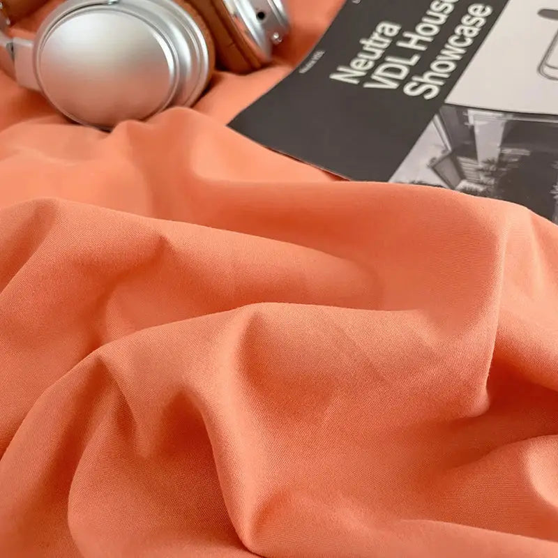 Soft peach-colored decorbites fresh solid color cotton quilt set showing smooth textured fabric folds