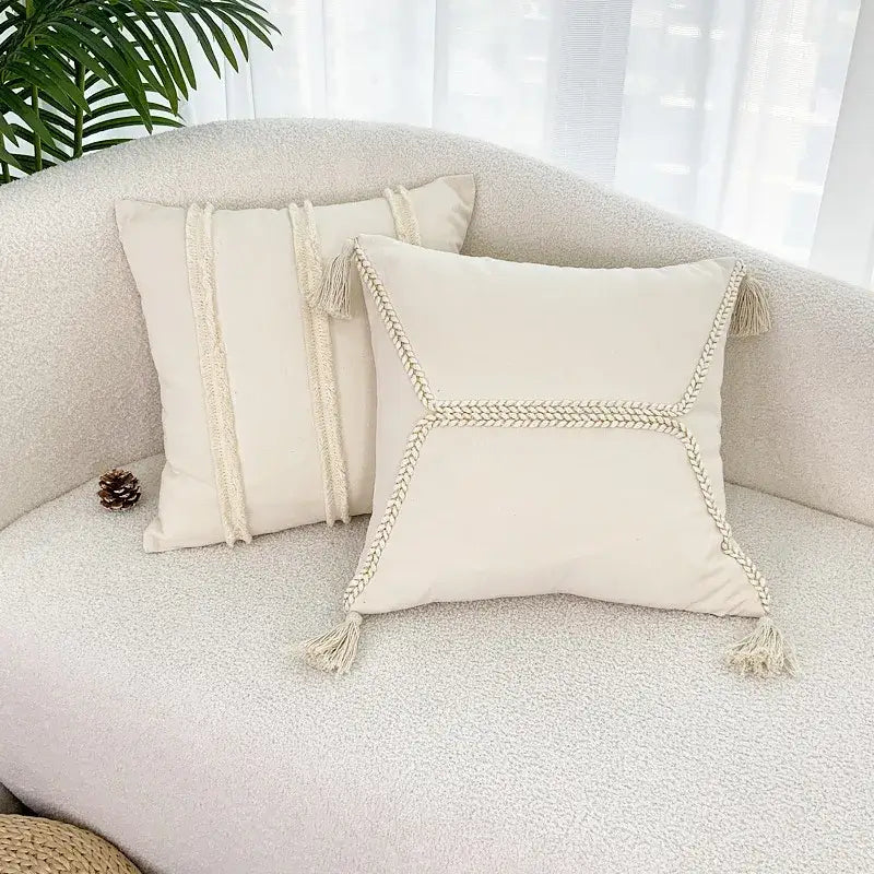 Cream-colored decorbites fringed geometry throw pillows with braided rope detailing and tassels for living room decor