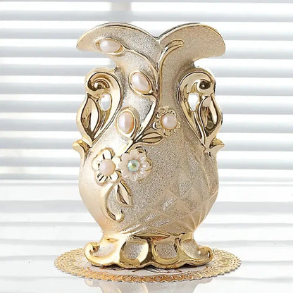 Gold-colored frosted porcelain flower vase with ornate floral designs and gemstone accent for elegant home decor