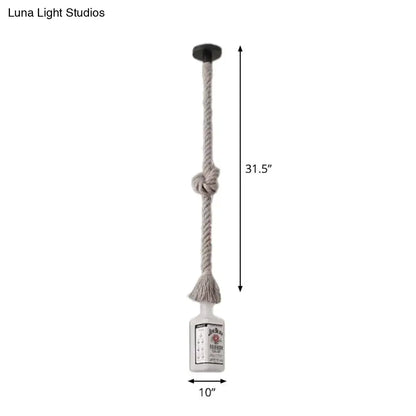 A frosted white glass pendant light shaped like a black wine bottle with beige rope cord and black ceiling mount