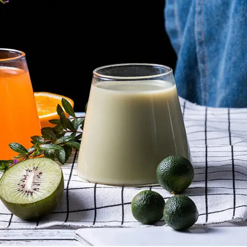 A clear glass tumbler filled with creamy pale green beverage from decorbites fuji mountain glass drinkware set