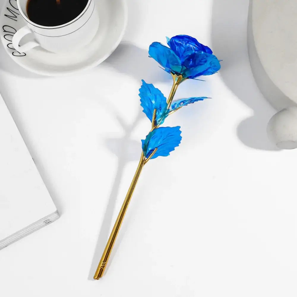 A decorbites galaxy rose centerpiece with a vibrant blue translucent petal and golden stem as a wedding decoration