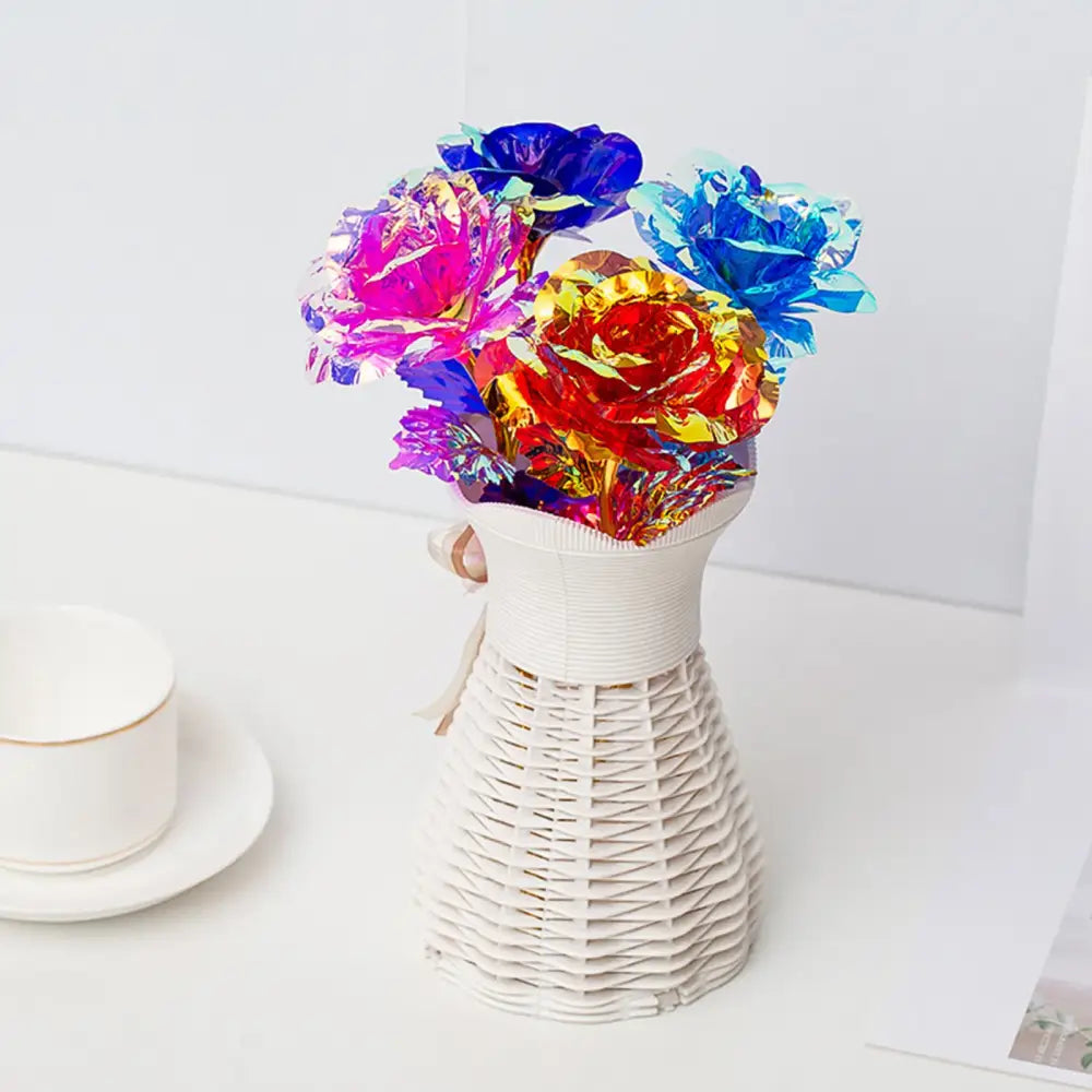 A white woven vase holding a decorbites galaxy rose bouquet with iridescent blue pink and gold metallic flowers