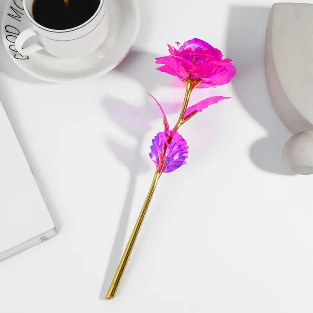 A vibrant pink and purple metallic galaxy rose with gold stem by decorbites perfect as a wedding centerpiece