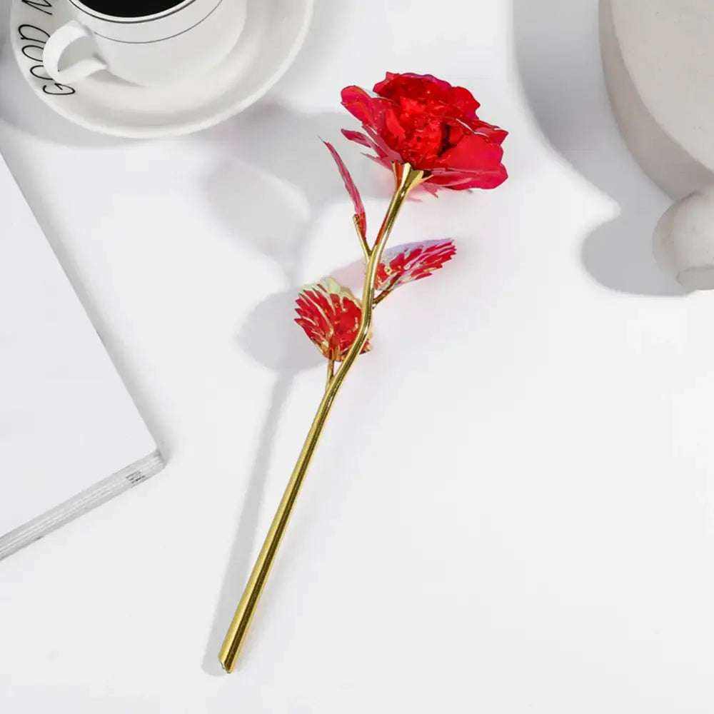 A vibrant red glass galaxy rose with a golden stem and leaves in the decorbites galaxy iridescent wedding centerpiece