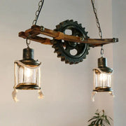 Decorbites gear industrial chandelier pendant featuring two glass lanterns with rope detail and metal gear on wooden beam