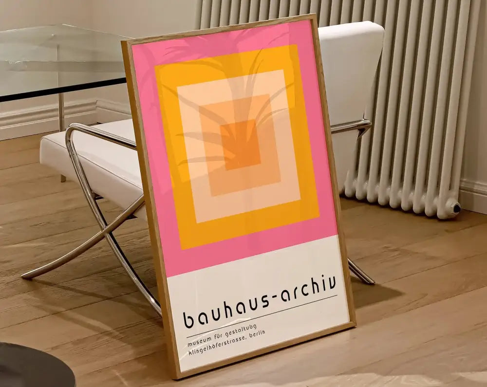 A framed decorbites™ geometric bauhaus canvas poster with concentric pink yellow and orange squares on a white background