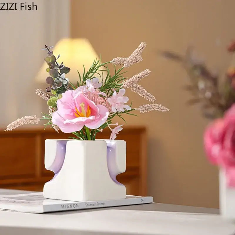 White ceramic decorbites geometric blocks vase with purple accents holding pink and white artificial flowers for decor