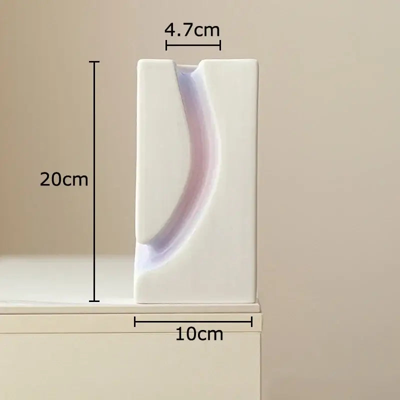 A sleek minimalist white ceramic decorbites geometric blocks vase with a smooth curved indentation for living room decor