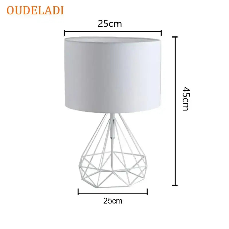 White oudeladi table lamp with geometric gold wireframe base and cylindrical shade for black bedroom desk light