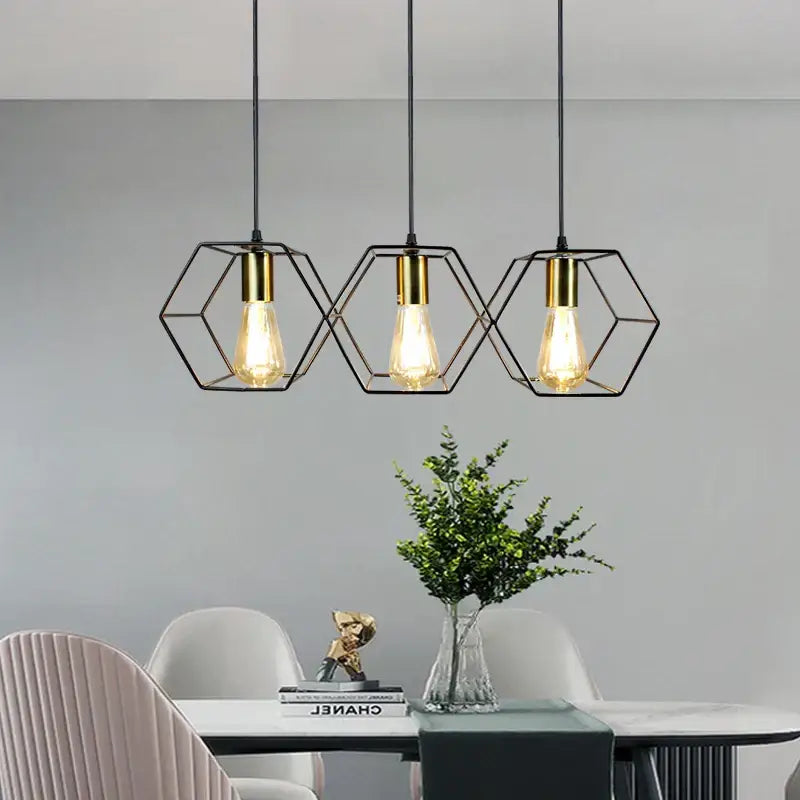 Three black hexagonal metal pendant lights with gold edison bulbs in decorbites geometric led chandelier design